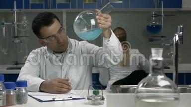 男科学家在实验室用液体检查烧瓶